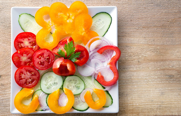 Salade de légumes frais tranchés sur une assiette blanche. L'épicerie est morte. Le concept d'aliments naturels sains. - Photo, image
