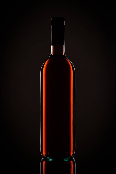red wine bottle with a black background - Foto, Imagem