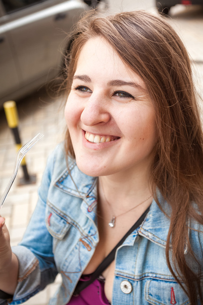 Porträt einer lächelnden jungen Frau mit Plastikgabel - Foto, Bild