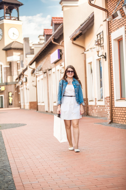 woman with white shopping bag walking on old street - Foto, Imagem