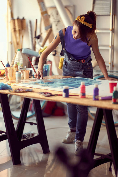 Cute female painter artist creating a new piece in the studio - 写真・画像