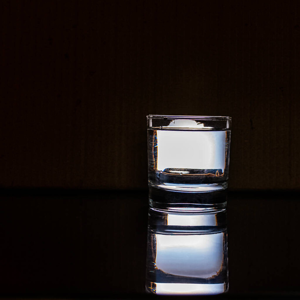 A glass of water in the dark - Фото, изображение