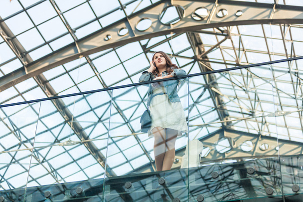 mujer hablando por teléfono celular en el aeropuerto con techo de cristal
 - Foto, Imagen