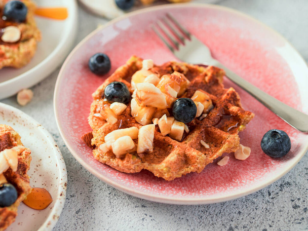 Easy healthy gluten free oat waffles with copy space. Appetizing homemade waffles with oat flour decorated blueberries, on plates over light gray cement background - Foto, Bild