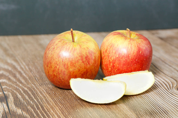 Два яблука на дерев'яному столі і шматки
 - Фото, зображення