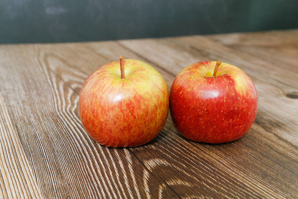Deux pommes sur table en bois, avec fond noir. - Photo, image