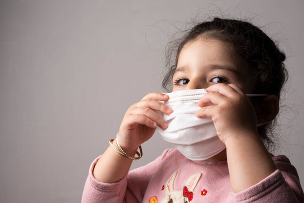 Little girl portrait wearing mask for protection from epidemic coronavirus, coronavirus outbreak and air pollution concept - Foto, Bild