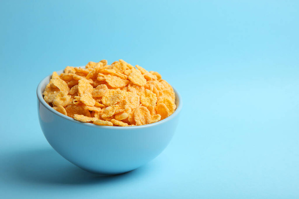 Delicious cornflakes in a plate against colored background.  - Фото, зображення