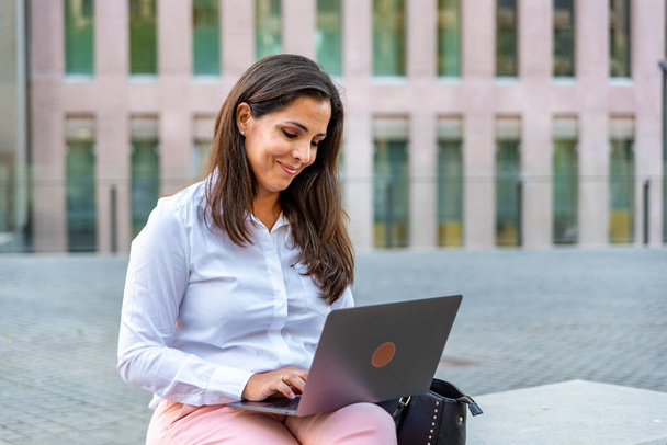 Mujer de negocios caucásica con ropa formal y computadora al aire libre - Foto, Imagen