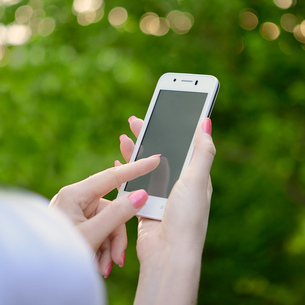 Mujer usando su teléfono móvil inteligente al aire libre
 - Foto, Imagen