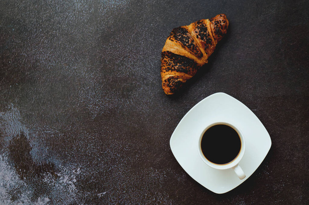 Geschäftsmann, der morgens mit Notizbuch, heißem Kaffee und süßem Croissant auf schwarzem Hintergrund arbeitet. Draufsicht, Kopierraum, Attrappe. Flach lag er. Moderne Frühstücksspeisen. - Foto, Bild