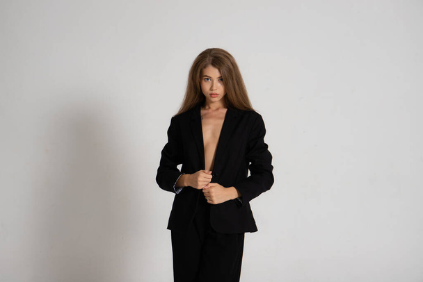 Girl in a black jacket and trousers on a white background - Фото, зображення