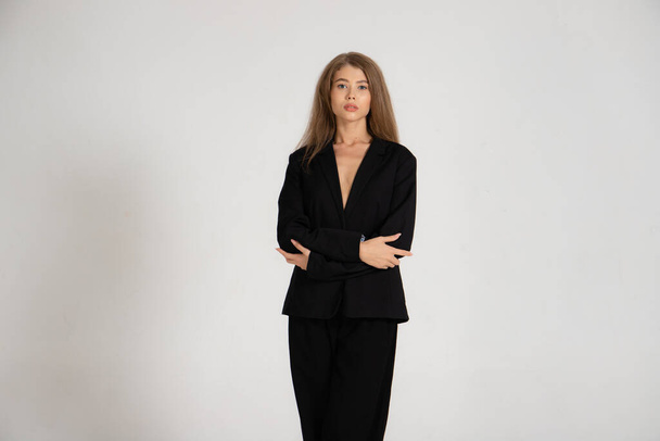 Girl in a black jacket and trousers on a white background - Foto, afbeelding