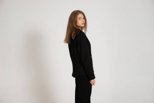 Girl in a black jacket and trousers on a white background - Foto, Imagem