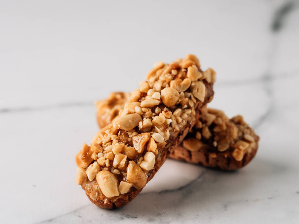 Homemade eclairs with peanut on marble background. Close up view of delicious healthy profitroles with nuts. Copy space for text or design. - Φωτογραφία, εικόνα