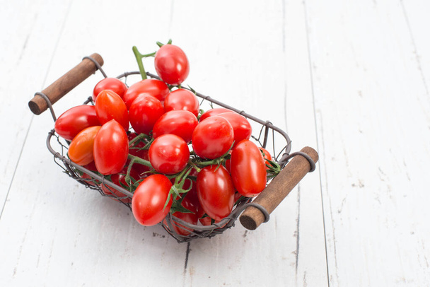 Red cherry tomatoes on a white textured background, empty space for text. - Foto, immagini