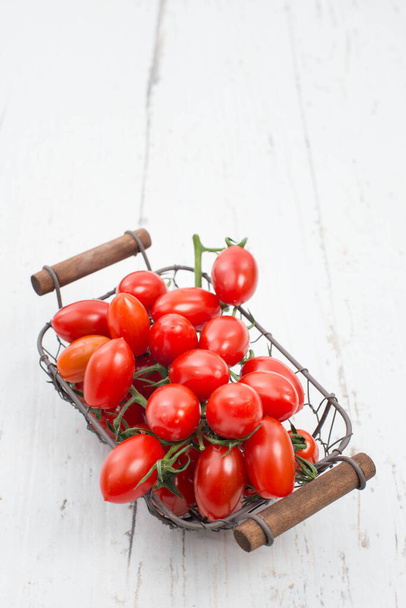 Red cherry tomatoes on a white textured background, empty space for text. - Fotoğraf, Görsel