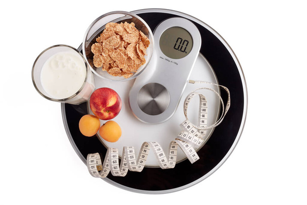 Slimming, diet, and control of weight. Still life with healthy food, scales and measuring tape. Healthy nutrition. Healthy lifestyle concept. Control of weight during the isolation period - Фото, изображение