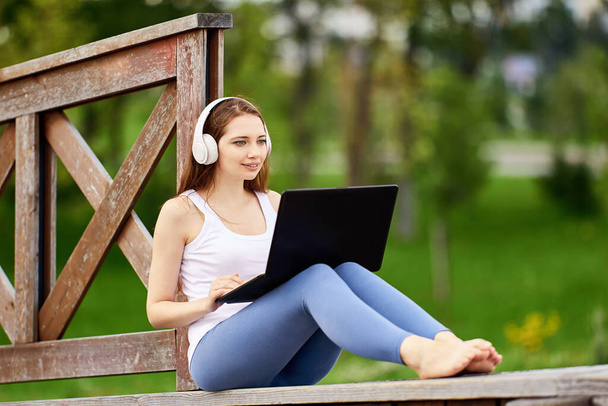 Woman talks with friends using laptop and Internet outdoors. - Φωτογραφία, εικόνα