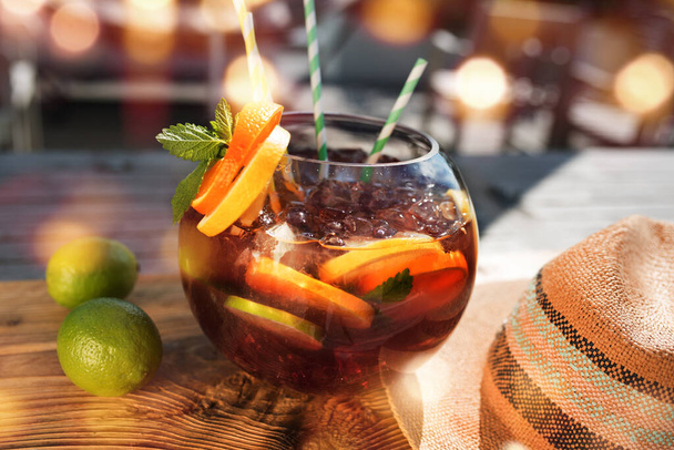 Summer scenery in a bar with fruity fresh sangria. Vacation background with straw hat and golden bokeh. Short depth of field and space for Text. - Zdjęcie, obraz
