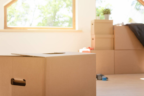 Move. Cardboard boxes for moving into a new, clean home. In a sunny day by a window in attic. - Foto, afbeelding