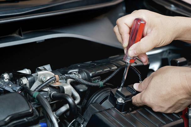 Techniker verwenden Schraubenzieher entfernen eine Schraube des Luftstromsensors im Maschinenraum Auto zur Überprüfung und Reinigung in Service-Konzept - Foto, Bild