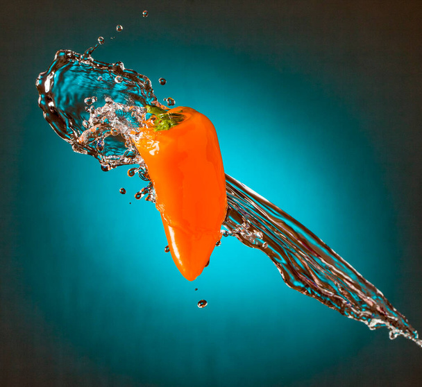 fresh ripe juicy orange juice with water splashes on a blue background - Fotó, kép
