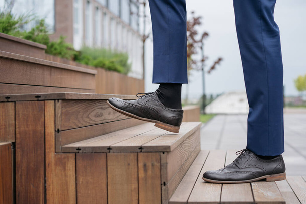 Businessman walking upstairs, focus on leather shoe. Startup, successful business, career concept  - Fotografie, Obrázek