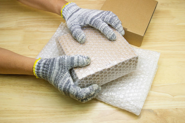 hand of man hold bubble wrap, for protection parcel product cracked or insurance During transit - Φωτογραφία, εικόνα