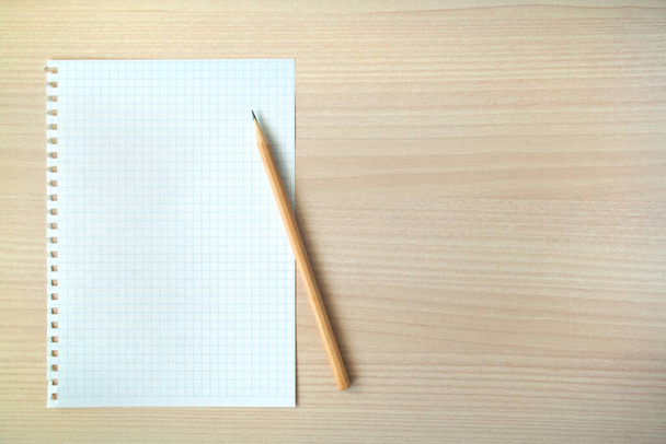 Pencil and pen with open clear notepad on wooden table, copyspace. - Photo, image