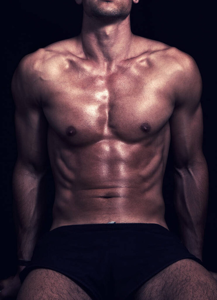 handsome muscular man with bare torso on black background - Foto, Imagen