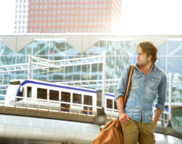 Fashionable young man traveling with bag - Photo, image
