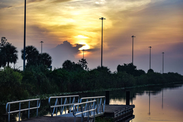 Отражения болотного восхода на причале - Фото, изображение