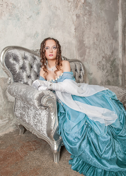 Beautiful woman in medieval dress on the sofa - Zdjęcie, obraz