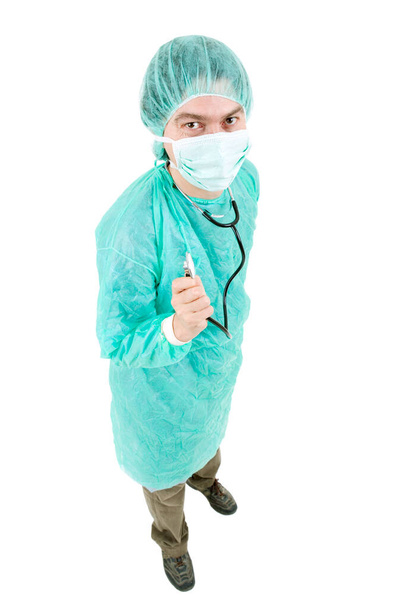 portrait of a young doctor in a white coat and a mask on a background of green - Foto, afbeelding