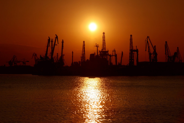 Auringonlasku Mustanmeren rannikolla Bulgariassa. Varnan teollisuussatama
. - Valokuva, kuva