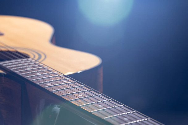 Acoustic guitar with beautiful wood on a black background in beautiful lighting. - Fotoğraf, Görsel