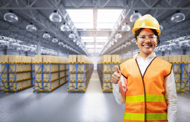 Asian worker in warehouse with stack of cardboard boxes - Foto, Bild