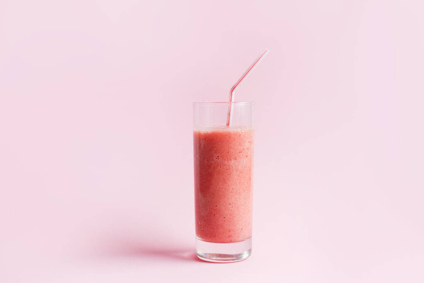 Клубничный коктейль или молочный коктейль в банке каменщика на розовом пастельном фоне. Здоровое питание на завтрак и закуски. - Фото, изображение
