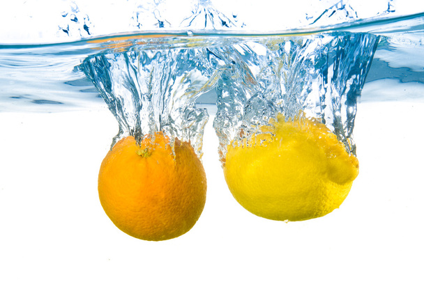 Lemon and orange fell into the water. Close-up - Foto, imagen