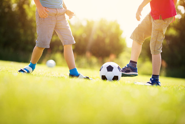 Boys playing football on the field with gates. Active children in summer with ball - Foto, Bild