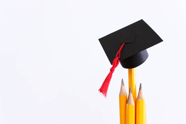 Image of education concept. Traditional graduation hat over pencils - Foto, Imagem