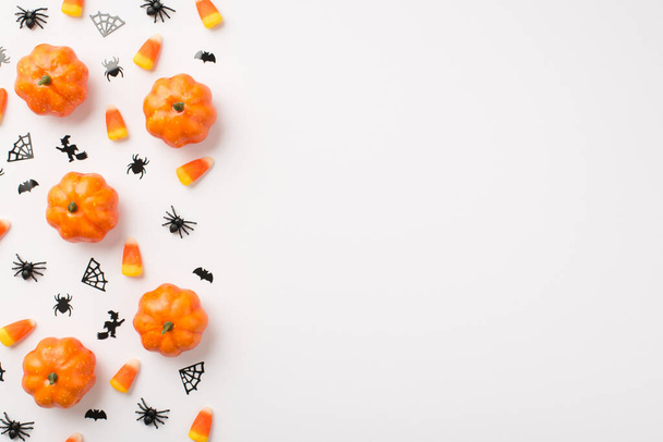 Над фото тыквы Хэллоуин декор пауки веб-ведьмы летучих мышей и конфеты, как кукуруза изолированы на белом фоне с копирайтом - Фото, изображение