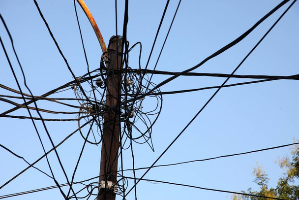 Um emaranhado de cabos de eletricidade e comunicações, antenas de televisão, antenas parabólicas em Prizren. - Foto, Imagem