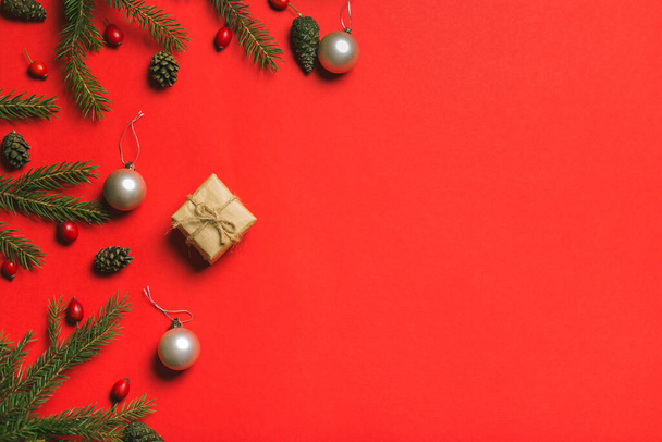 Composição de Natal. Quadro feito de presentes de Natal, ramos de pinho, isolado no fundo vermelho. Deitado plano, vista superior. - Foto, Imagem
