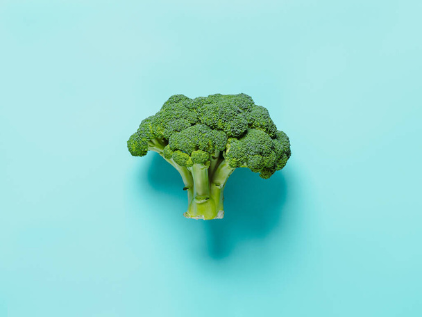 Broccoli on blue background. Fresh tasty green broccoli with copy space, top view or flat lay. - 写真・画像