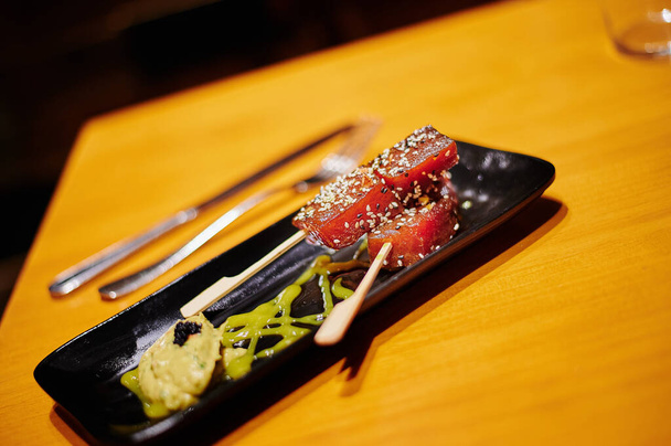 rolo de sushi com salmão e pauzinhos em uma tábua de madeira - Foto, Imagem