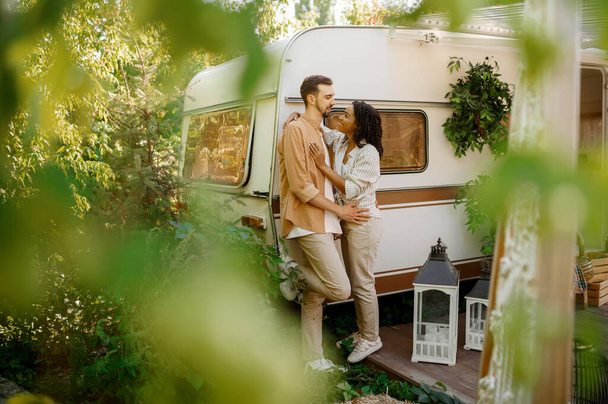 Love couple embraces in rv, camping in a trailer. Man and woman travels on van, romantic vacations on motorhome, campers leisures in camping-car - Valokuva, kuva