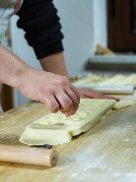 Close-up of woman's hands working the dough to prepare cheese ravioli. Traditional Sardinian cuisine. - Photo, Image