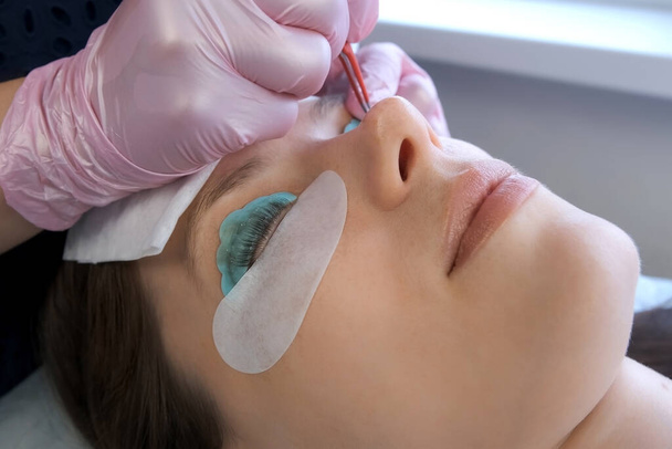 Beautician bending lashes with needle into curlers, lift eyelashes laminaton. - Фото, изображение